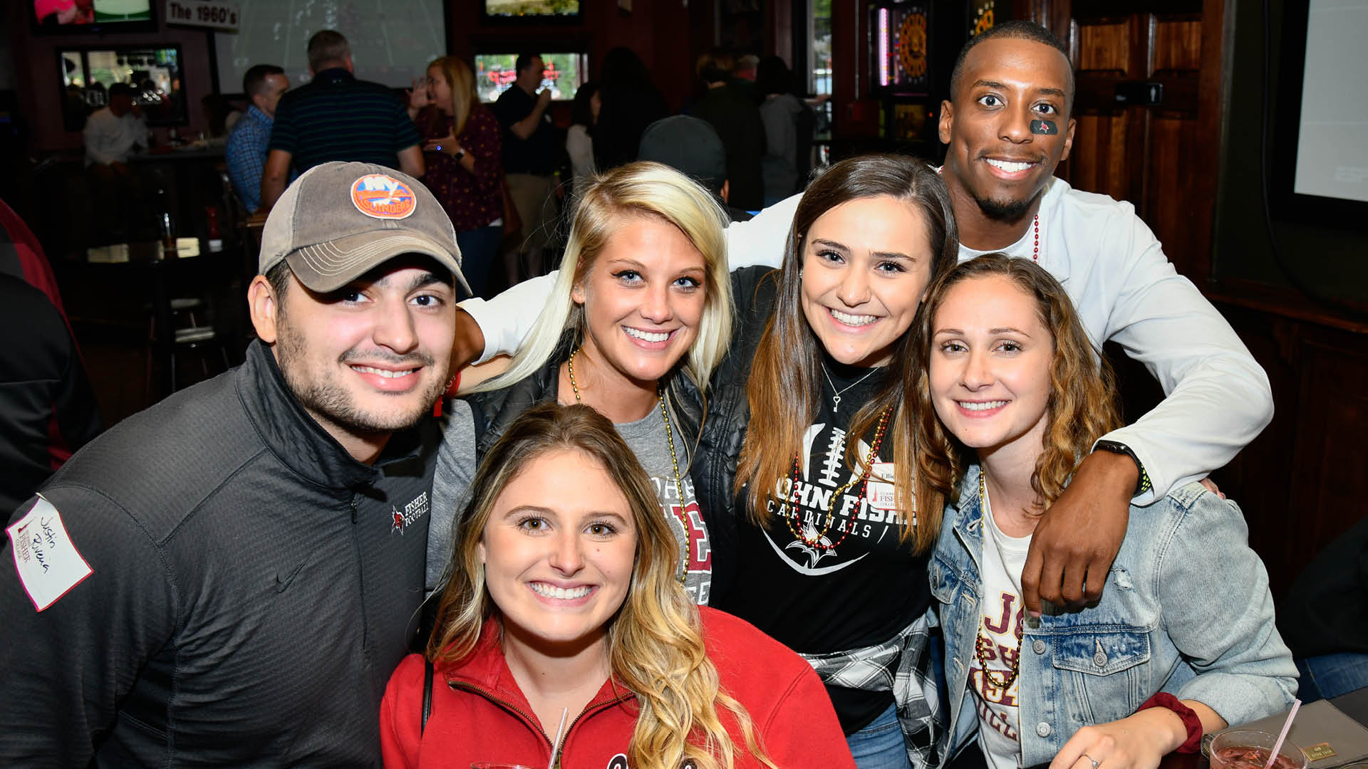 A group of five young alumni celebrating together at Alumni and Family Weekend