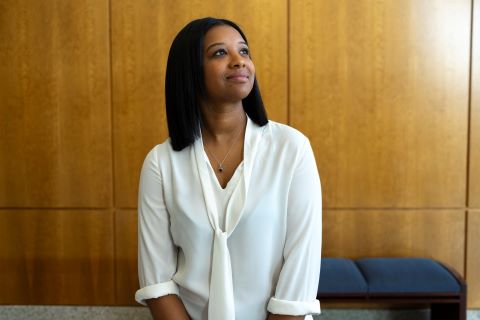 A woman in a white blouse looking up.