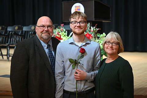 A graduate poses with family members.