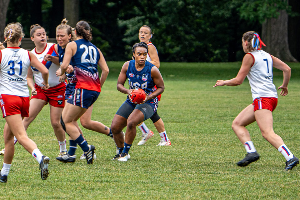 Fisher alumnus Rita Hill runs with the ball.