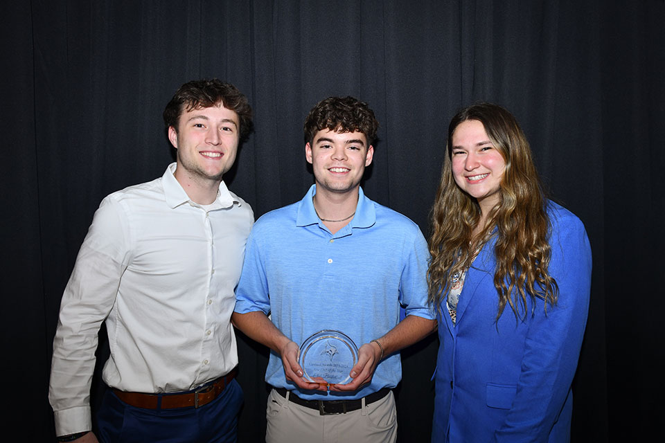 Jenna Hoffman, Brendan Evans, and Adam Jones pose with the New Club of the Year Award at the 2024 Cardinal Awards ceremony.