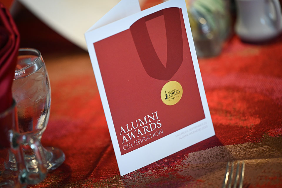 A program for the Alumni Awards sits on a table.