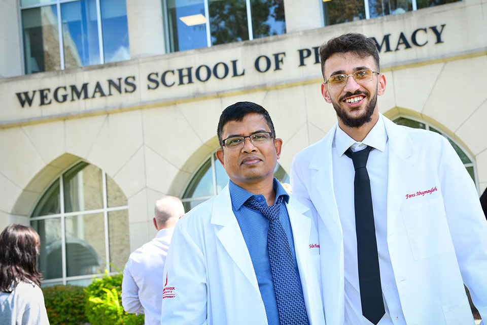 Two pharmacy students wearing their new white coats.