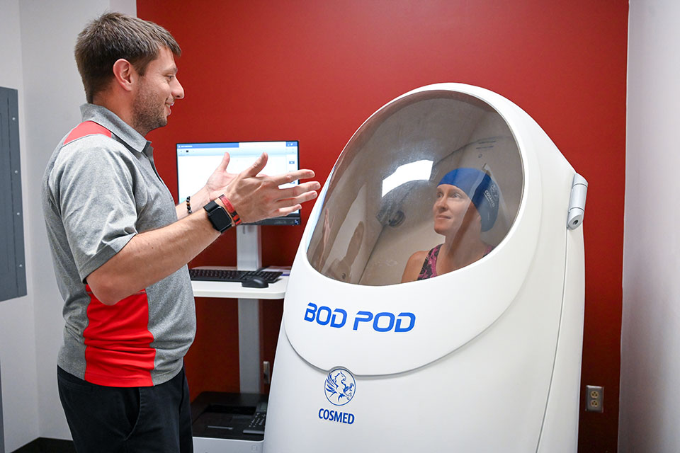 Dr. Wells works with an athlete in the Bod Pod.