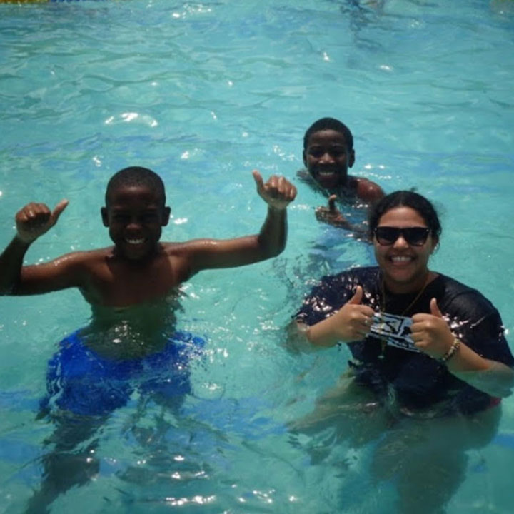 Leilani Monegro (right) swims with two campers during the JASY program.