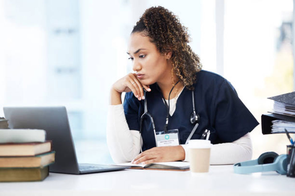 A nurse works at a computer.