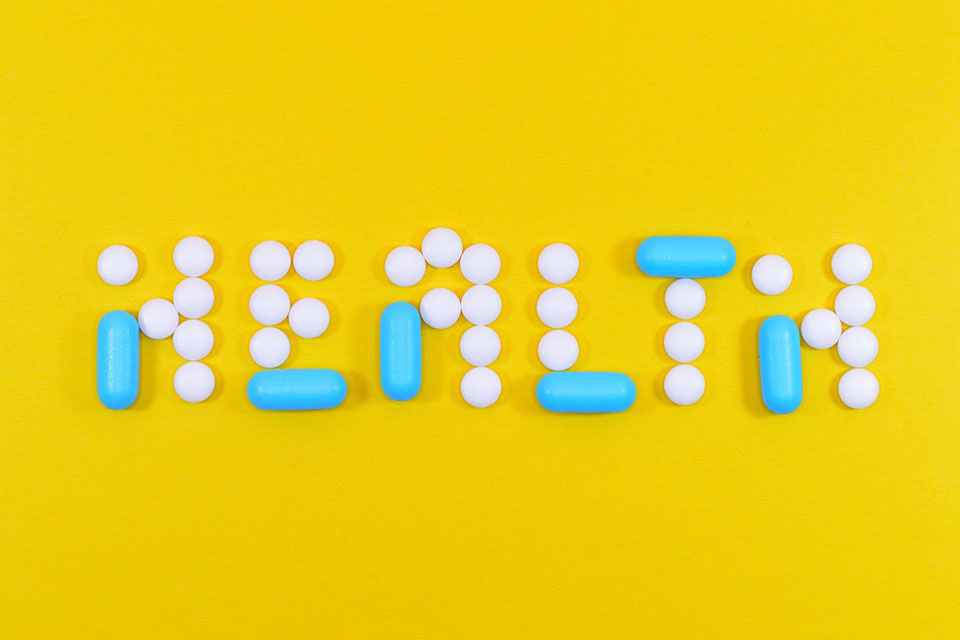 Pills spell out the word health.