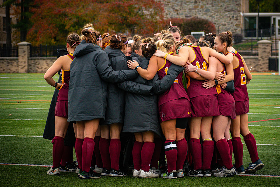 Fisher's field hockey team huddles during a game.