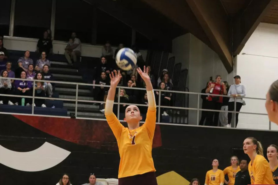 A player on the women's volleyball team goes to set the ball.