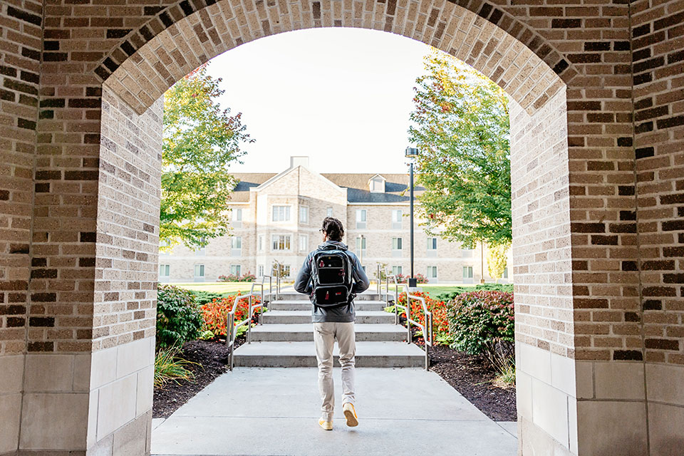 A student walks through the campus quad.