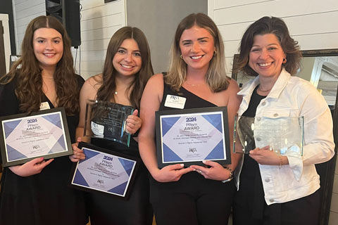 Three students and faculty displaying their PRism awards