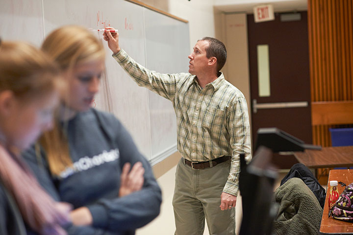 Professor writting on white board