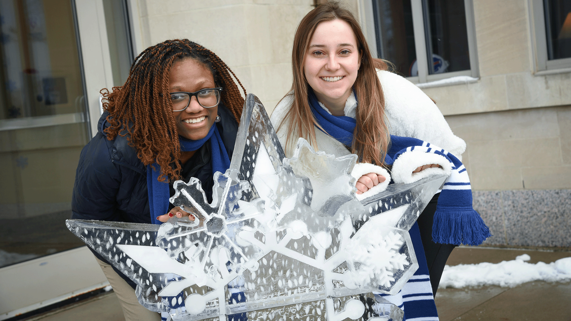 Students smile behind an enlarged snowflake.