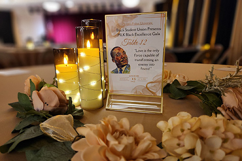 Table centerpiece with candles and welcome to the Spirit of Identity Week Black Excellence Gala.