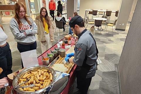 A chef creates food for sampling.