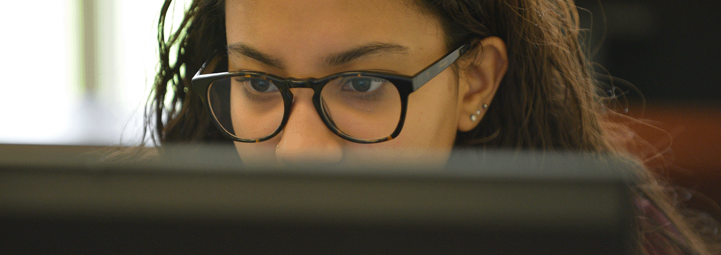 A student looks over a computer.